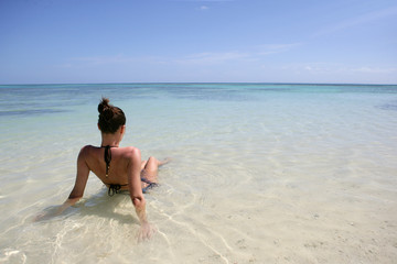 Jeune femme assise dans l'eau se baignant à la mer