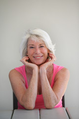 Portrait d'une femme senior souriante assise à une table