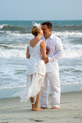 Bride and groom kissing at the oceanfront