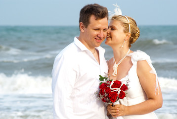 Young beautiful bride whispering to the groom and smiling