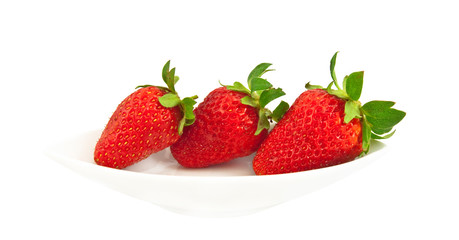 Three ripe strawberries on a white plate