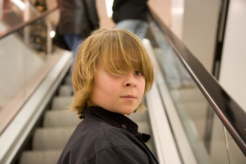 Kind auf der Rolltreppe eines Shopping Centers