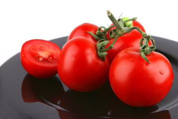 fresh uncooked tomato close up on black