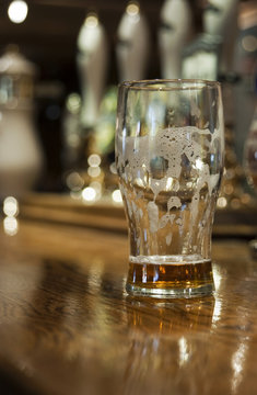 Emtpy beer glass on bar at public house, england.