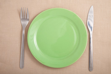 fork and knife near green plate