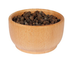 black dry pepper is in a wooden dish