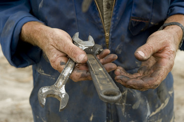 man's greasy hands holding tools - obrazy, fototapety, plakaty
