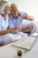 Obraz premium Couple de seniors souriants connectés à une webcam