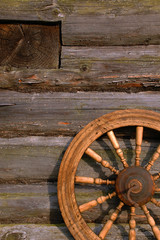 Obraz premium Spinning Wheel On The Log Hut Wall