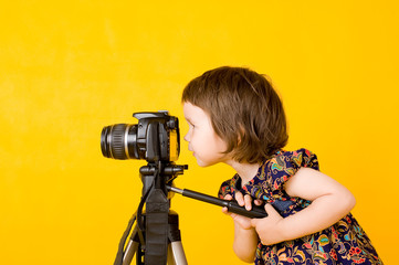Baby girl holding photo camera - obrazy, fototapety, plakaty