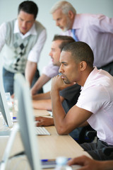 Fototapeta na wymiar Młody mężczyzna rasy mieszanej siedzi przy komputerze