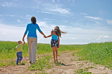 Young family running over a farmer  field