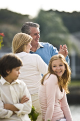 Mature couple dancing outdoors, daughter and son in foreground