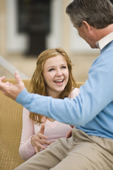 Father and teenage daughter talking outdoors