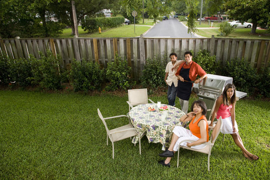 Interracial family having back yard barbeque