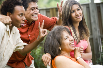Interracial family making silly gestures posing for photograph