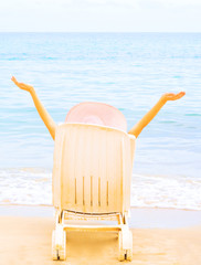Fototapeta na wymiar Girl welcoming sun in chaise longue