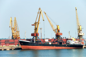 The trading seaport with cranes, cargoes and ship