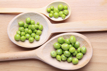 Grains of green beans in wooden spoon
