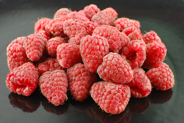 fresh raspberry on black dish