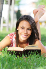 entertainment of young woman in green park, book and reading