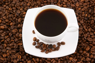 White cup of coffee on coffee grains background