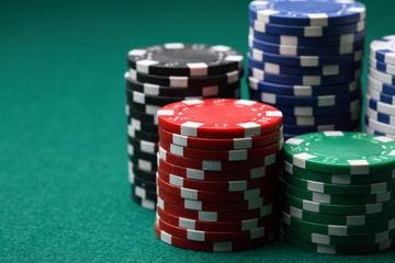 Stacks of poker chips on a green surface.