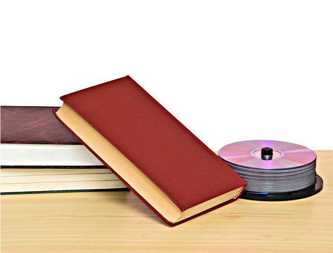 Pile of books  and DVD disk pack as symbols of old and new metho