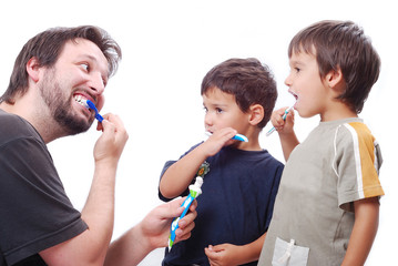 Young man teaching kids how to clean the teeth