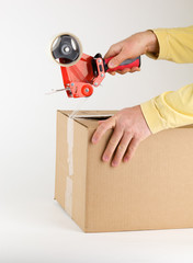 Closing a cardboard box with tape