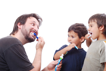 Father teaching his two sons how to clean the teeth