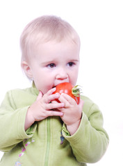 A little cute girl eating tomato