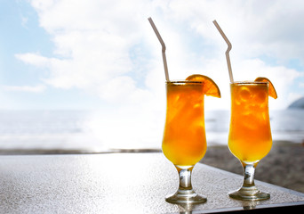 two glasses of orange juice on sky background
