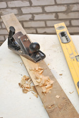 old plane on wooden table with shavings