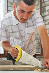 a joiner sawing a plank