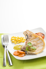 tasty pork chop with corn carrot tomato