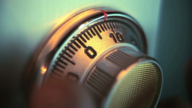 Man turning combination lock on safe