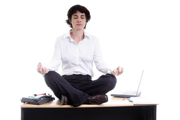 Femme d'affaires faisant du yoga sur son bureau