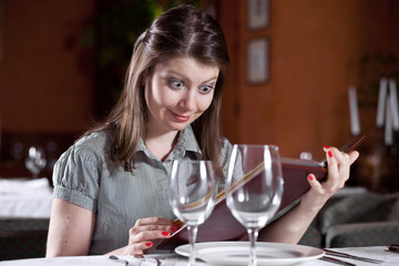 The girl with surprise looks in the menu