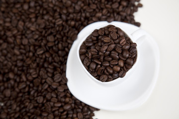 Cup with beans coffee on white