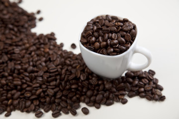 Cup with beans coffee on white