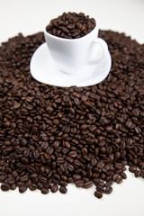 Cup with beans coffee on white