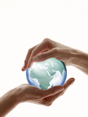 Two hands encircling a digitally created glass globe