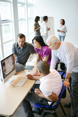 Hommes et femme en formation commerciale et informatique