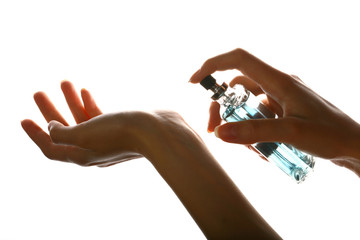 woman applying perfume on her wrist, bright red perfume bottle