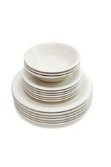 Stack of beige dinner plates, soup plates and saucers isolated