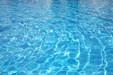 transparent water with patches of light from the sun in pool