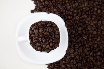 Cup with beans coffee on white