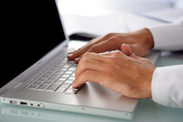 Homme d'affaires tapant sur le clavier d'un ordinateur portable