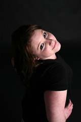 teen with head tilted against dark background